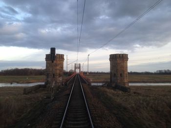 Railroad track against cloudy sky