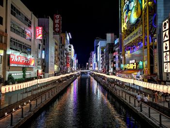 Illuminated canal amidst buildings in city at night