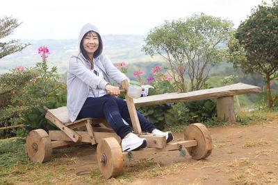 Portrait of smiling young woman sitting outdoors