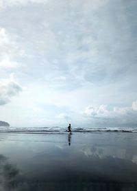 Silhouette of a person running on the beach