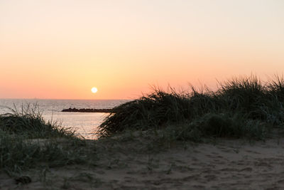 Scenic view of sea against clear sky during sunset