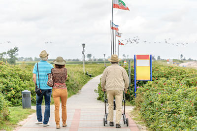 Rear view of people walking on field