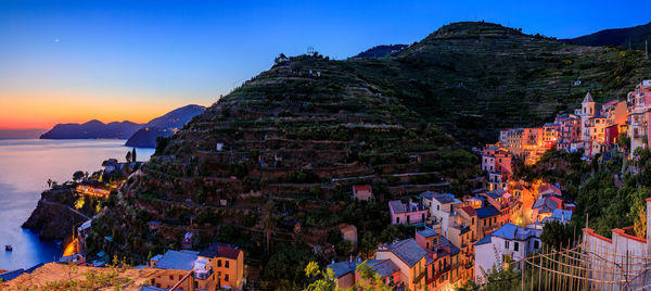 High angle view of townscape by sea against sky during sunset