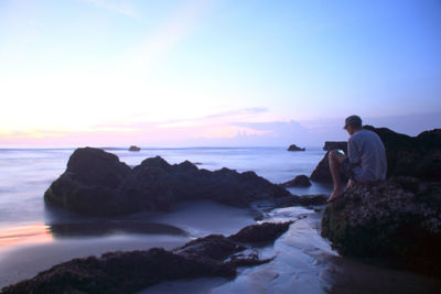 Rear view of people looking at sea against sky