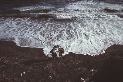 High angle view of people standing on beach