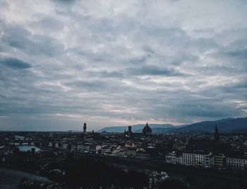 Cityscape by sea against sky