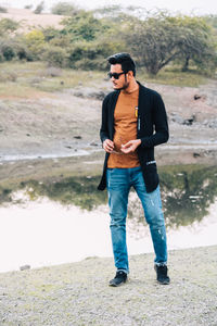 Full length of young man wearing sunglasses standing outdoors