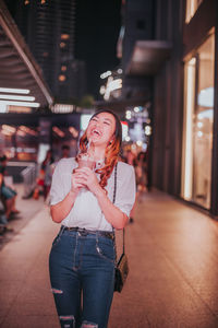 Woman holding ice cream standing outdoors