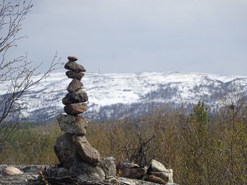 Stack of stones against sky during winter