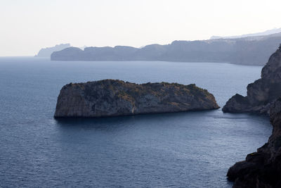 Rock formations in sea against sky