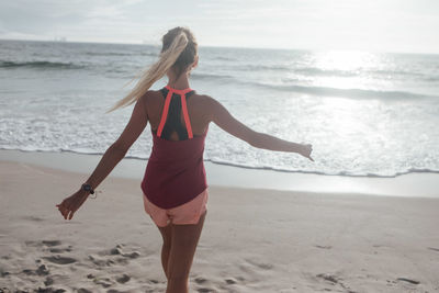 Rear view of woman standing at beach during summer