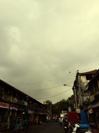 Cars parked on road against cloudy sky