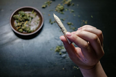 Cropped hands of man holding marijuana joint