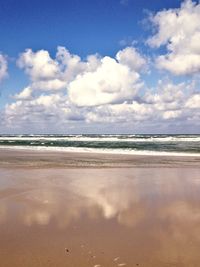 Scenic view of beach against cloudy sky