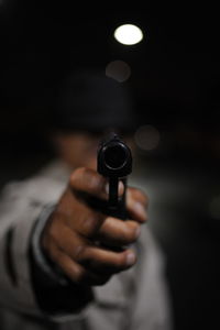 Midsection of man holding gun