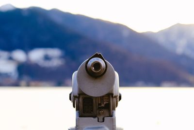 Close-up of coin-operated binoculars against sky