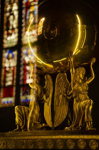 Close-up of statue against illuminated building