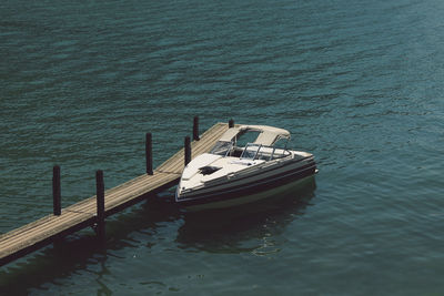 High angle view of motorboat moored by pier in river