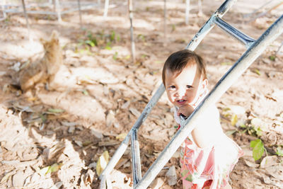 A little girl is hanging on a bar and smiling. the child goes in for sports. healthy lifestyle.