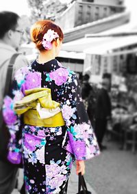 Midsection of woman with umbrella walking in city