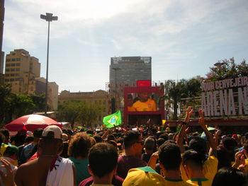 People on street in city against sky