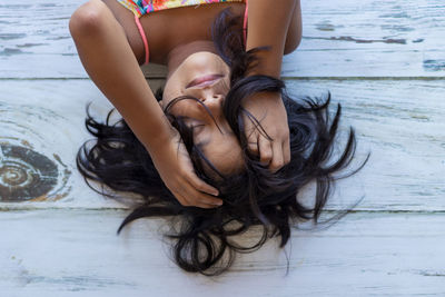 High angle view of girl with eyes closed lying on floor