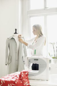 Woman preparing coat on mannequin