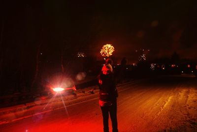 Man standing in city at night