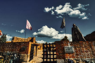 Low angle view of flags on building against sky