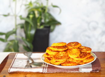Fried pumpkin pancakes on a gray background with home plant. diet food idea.