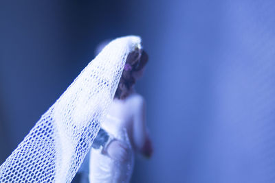 Close-up of woman against blue background