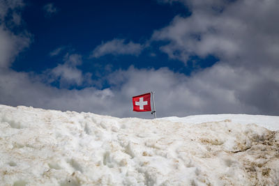 Low angle view of flag on snow against sky