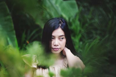 Woman looking away against plants