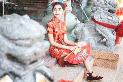 Midsection of woman sitting on sculpture