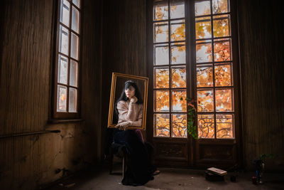 Woman sitting by window at home