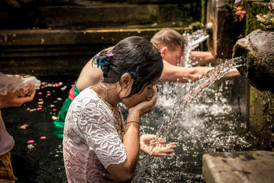 People drinking water from fountain