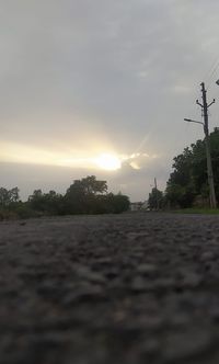 Surface level of road against sky during sunset