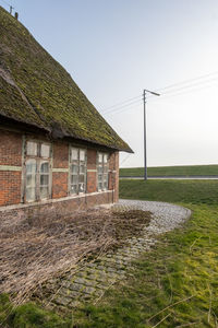 House on field against clear sky