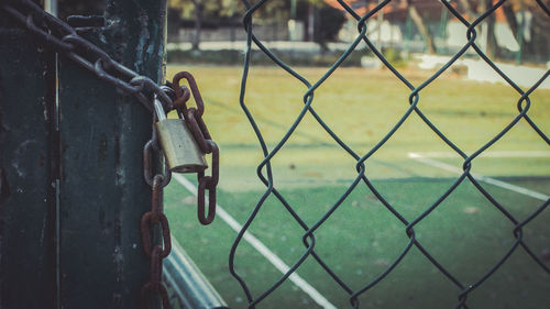 Close-up of padlock on chainlink fence