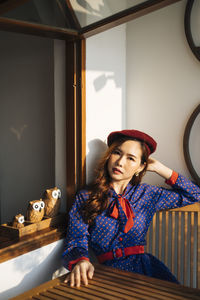 Young woman looking away while sitting on table