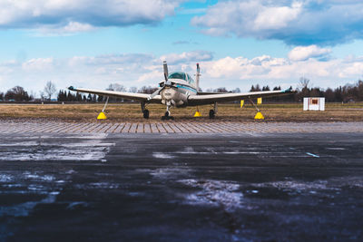 Airplane on runway against sky