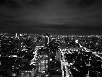 Illuminated cityscape against sky at night