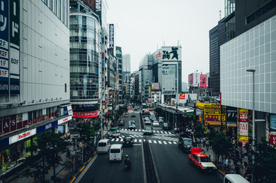 Traffic on city street amidst buildings against sky