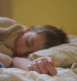 Close-up of boy sleeping on bed at home