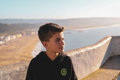 Portrait of boy looking away against sky