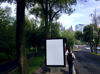 Rear view of man and woman standing on footpath