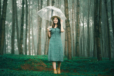 Full length of a woman standing in forest