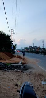 Electricity pylon on land against sky in city