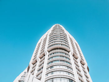 Low angle view of modern building against clear blue sky