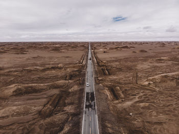 Scenic view of desert road against sky